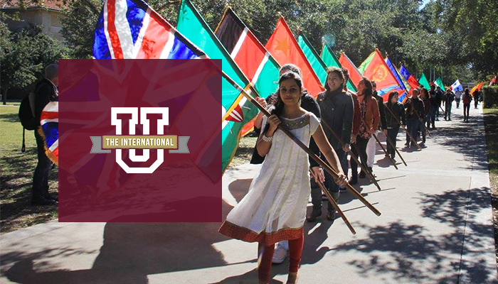 Students holding flags from around the world at Texas A&M International University.